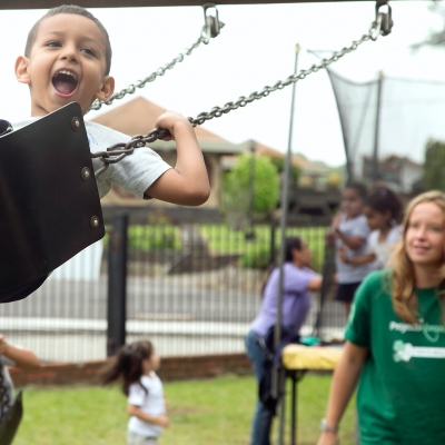 A Projects Abroad volunteer pushes a young boy on a swing during her Childcare volunteer work in Costa Rica Children play on the swings under the supervision of a volunteer working with children in Costa Rica